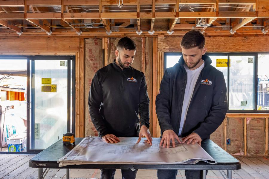 Bark and Build project lead and crew reviewing blueprints on-site — single point of contact accountability model