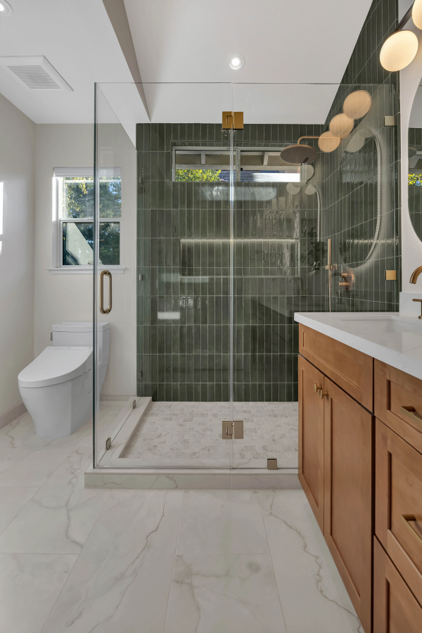 Master bath, full room view with green tile shower, glass enclosure, and marble floor