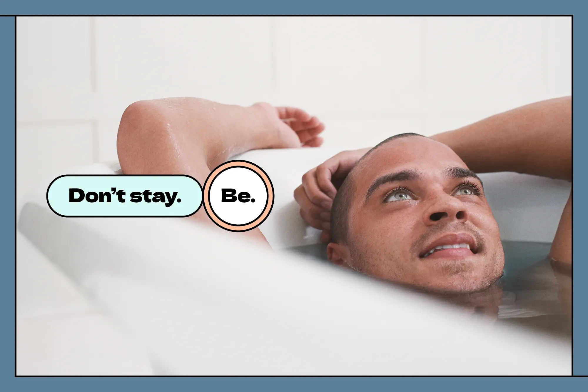 A man relaxes in a deep bath, looking satisfied, with the text 'Don't stay. Be.'