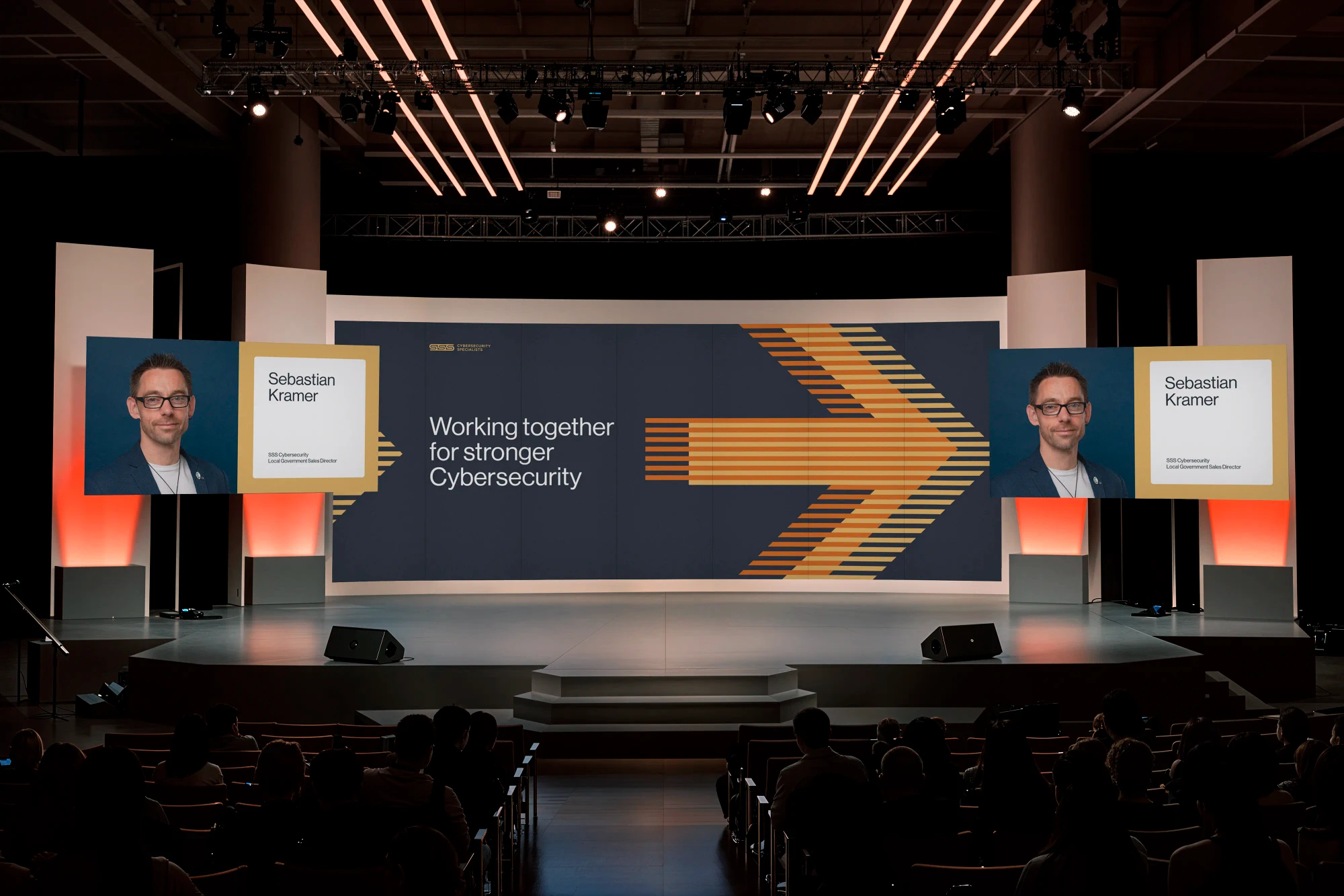 Conference screens feature graphics for a keynote speech