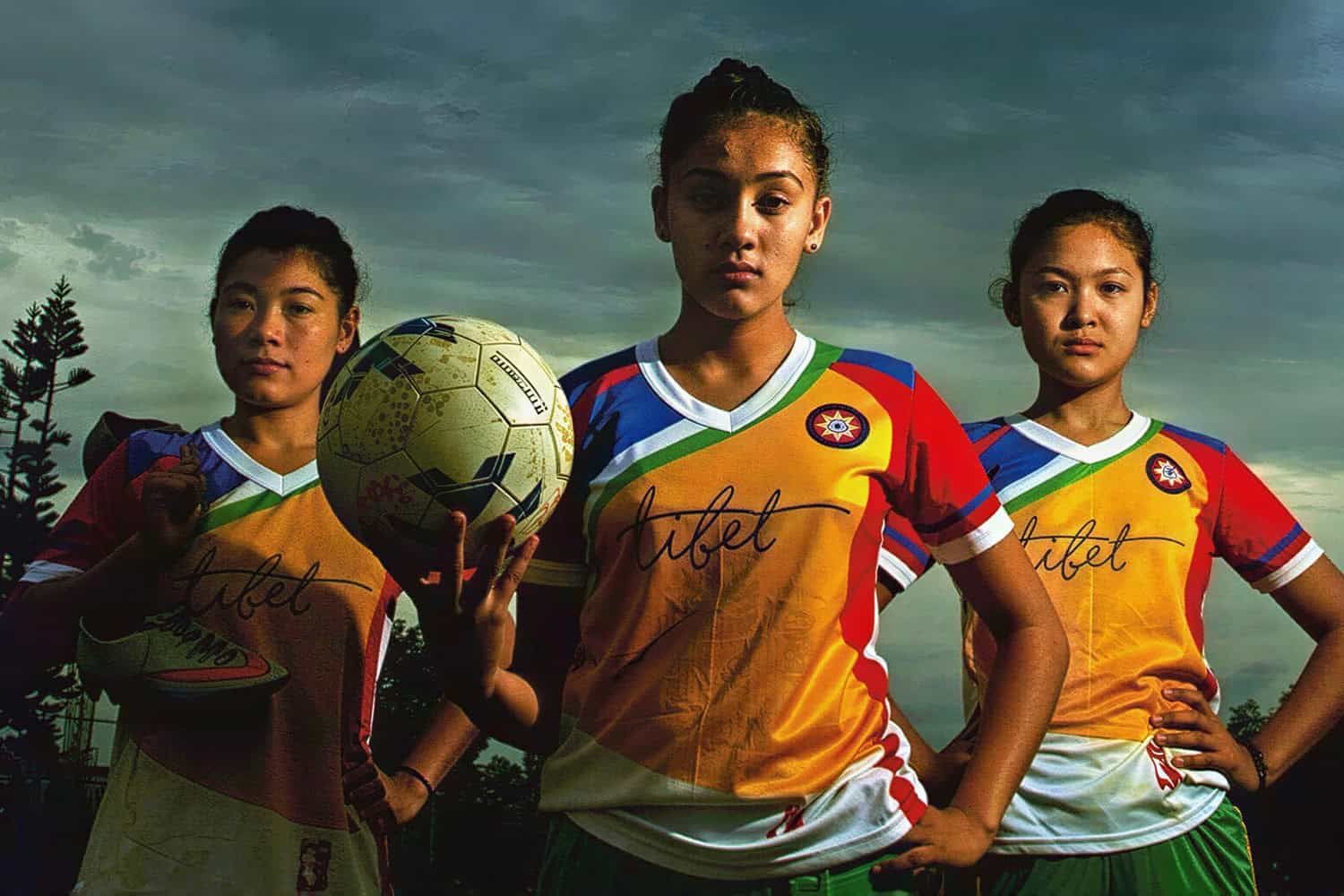 Young nuns in football kit holding a ball