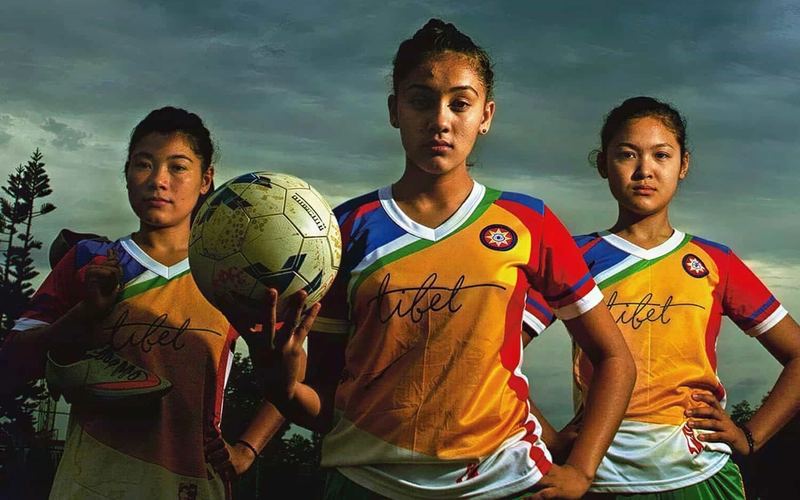 Young nuns in football kit holding a ball