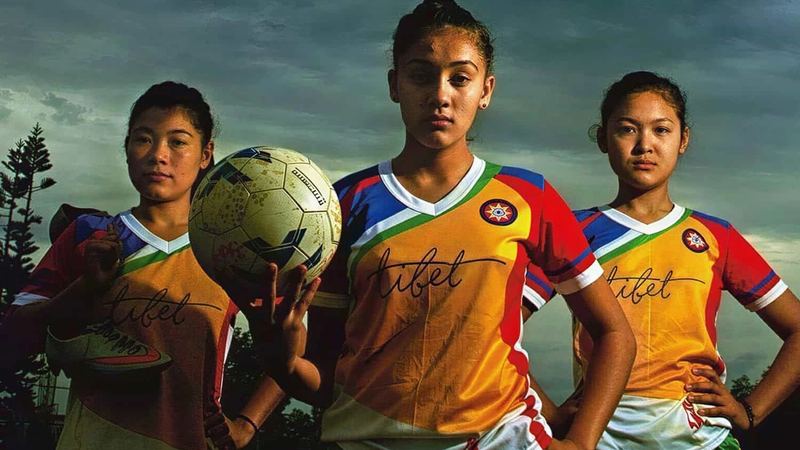 Young nuns in football kit holding a ball
