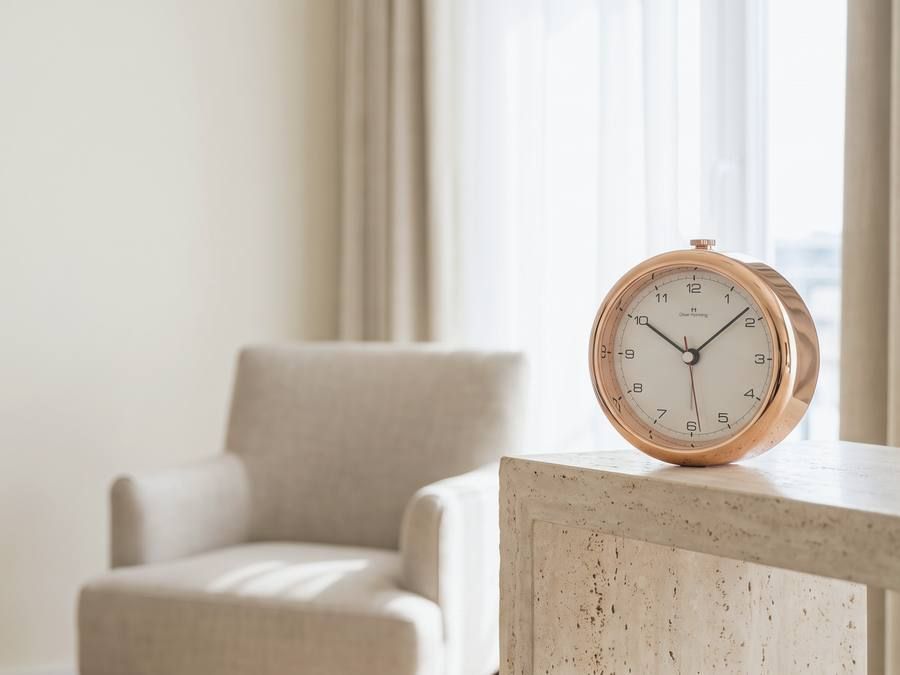 An Oliver Hemming Desire clock on a console in a daylit sitting room