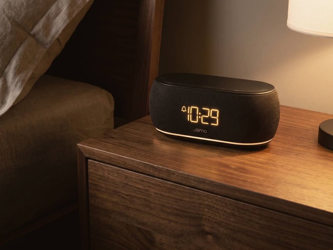 A Jamo HYG Reflect on a walnut nightstand at night