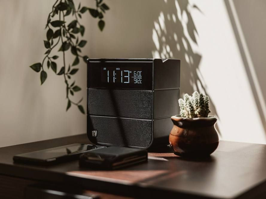 A Soundfreaq Sound Rise II on a bedside table in morning light