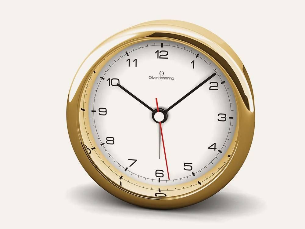 An Oliver Hemming Desire clock with a white dial
