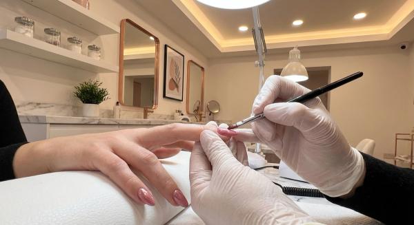 Nail technician carefully painting a client's nails at Bliss Nails & Spa