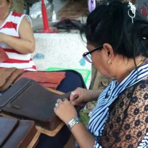 ช่างฝีมือกำลังเย็บกระเป๋าหนังด้วยมือ สะท้อนความใส่ใจในทุกรายละเอียด