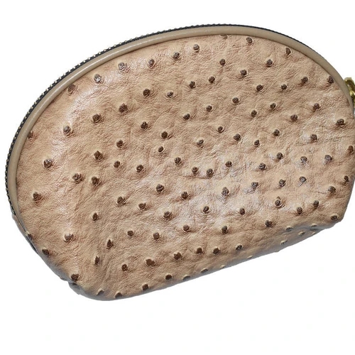 กระเป๋าหนังนกกระจอกเทศสีเบจทรงโค้ง มีซิป และผิวสัมผัสเป็นปุ่มนูนอันเป็นเอกลักษณ์