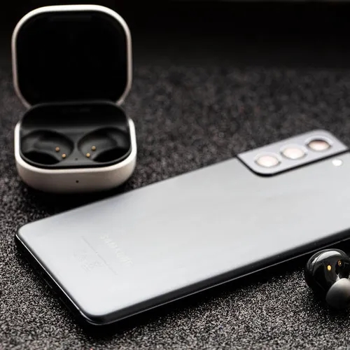 หูฟังไร้สายและสมาร์ทโฟนบนโต๊ะทำงาน