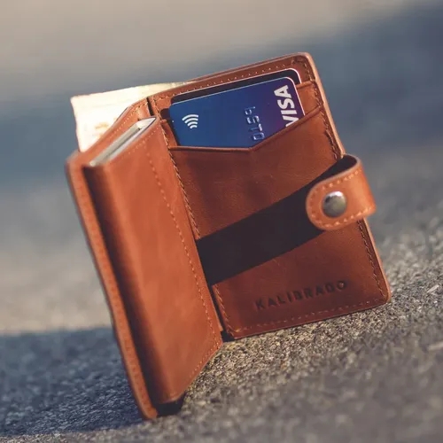 กระเป๋าสตางค์หนังสีน้ำตาลที่เปิดอยู่พร้อมบัตรและเงินสด