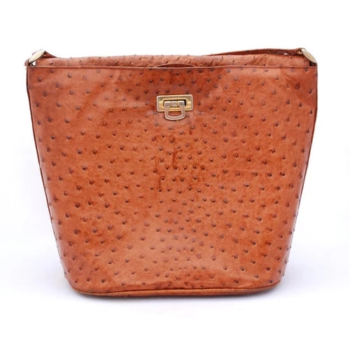 กระเป๋าถือหนังนกกระจอกเทศสีน้ำตาลอ่อน มีลวดลายเป็นปุ่มนูนชัดเจนและตัวล็อกสีทองด้านหน้า