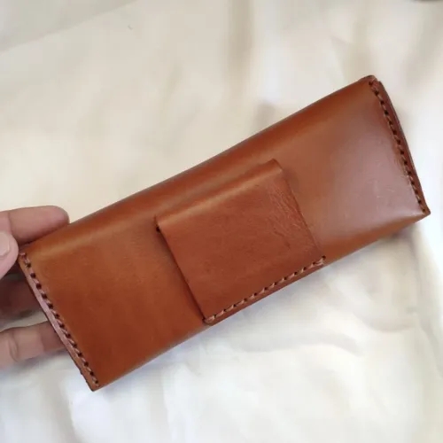 ซองแว่นตาหนังแท้สีน้ำตาล ทำจากหนังฟอกฝาดอิตาลี สามารถร้อยเข็มขัดได้ วางบนพื้นหลังสีขาว - 03