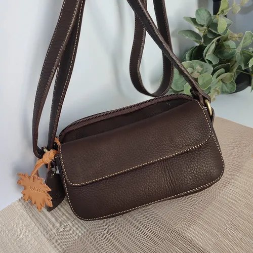 ใช้ผ้าสะอาดซับน้ำออกจากกระเป๋าหนังอย่างเบามือ