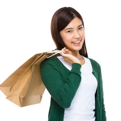 ผู้หญิงยิ้มพร้อมถุงช้อปปิ้งที่เป็นมิตรต่อสิ่งแวดล้อม