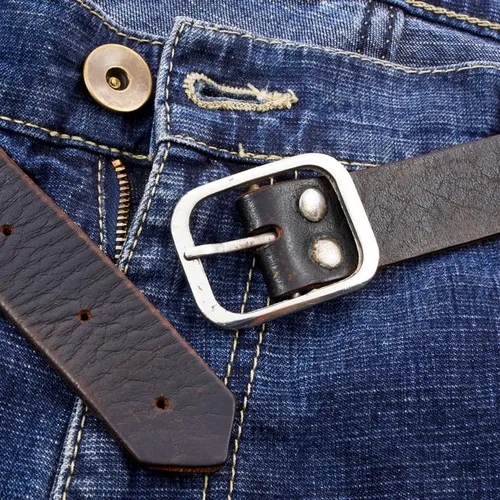 เข็มขัดหนังสีน้ำตาลบนกางเกงยีนส์ สะท้อนการใช้งานในชีวิตประจำวัน