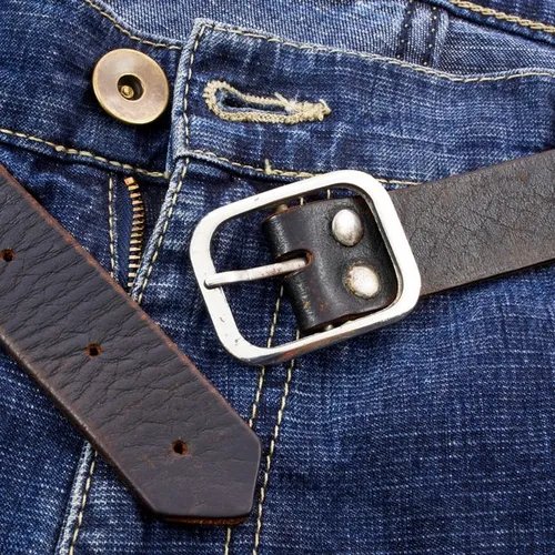 เข็มขัดหนังสีน้ำตาลบนกางเกงยีนส์ สะท้อนการใช้งานในชีวิตประจำวัน