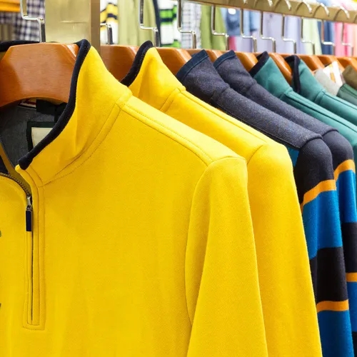 เสื้อโปโลผู้ชายหลายสีแขวนบนราวแสดงตัวเลือกที่น้อยกว่าแฟชั่นผู้หญิง