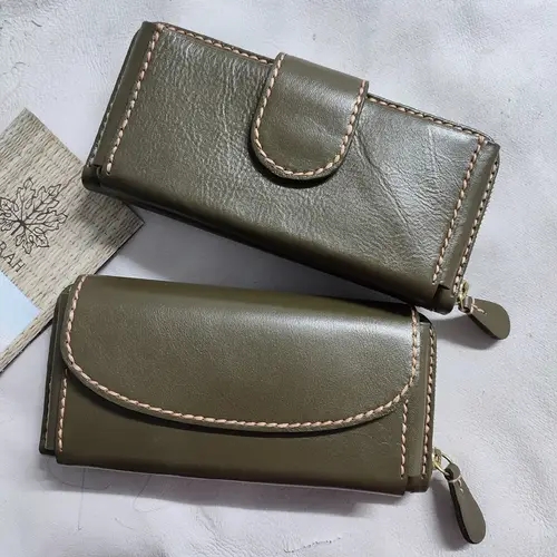 กระเป๋าสตางค์หนังสีเขียวมะกอก 2 ใบ ดีไซน์เรียบหรู พร้อมงานเย็บด้ายสีครีมที่ขอบอย่างประณีต