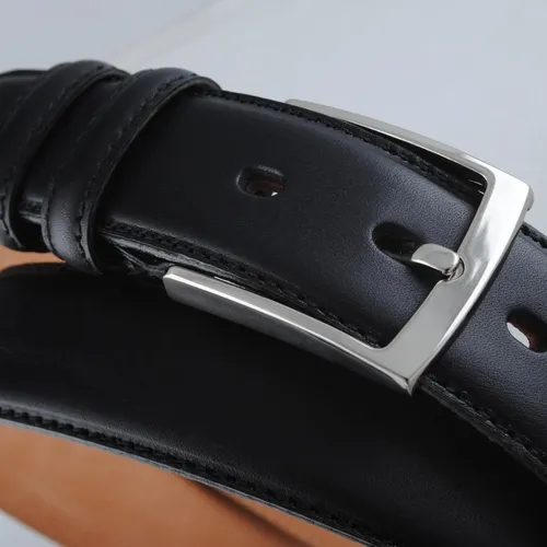 เข็มขัดหนังสีดำวางอยู่บนพื้นหลังสีขาว