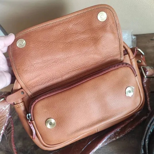 กระเป๋าถือหนังแท้ชามัวส์สีน้ำตาลเข้ม ดีไซน์คลาสสิก พร้อมสายสะพายปรับระดับได้ วางบนพื้นหลังสีขาว - 01