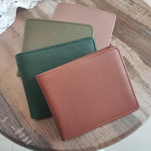 กระเป๋าสตางค์หนังหลากสี 4 ใบวางซ้อนกันบนพื้นโต๊ะไม้