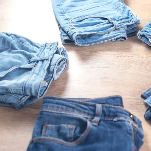 กางเกงยีนส์หลายตัวพับซ้อนกันอย่างเป็นระเบียบ