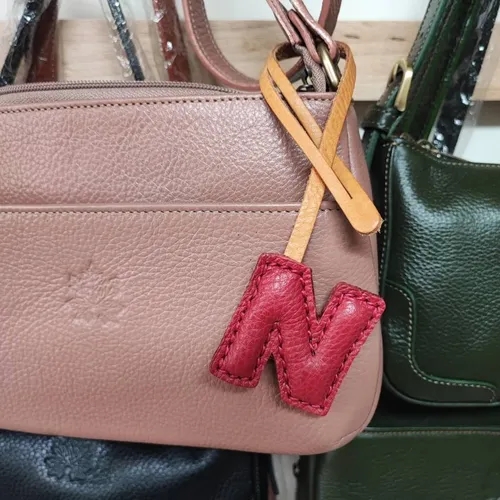 ที่ห้อยกระเป๋า N หนังแท้สีน้ำตาลเข้ม แขวนอยู่บนหูกระเป๋าถือของผู้หญิง - 01