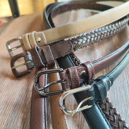 เข็มขัดหนังหลายเส้นสีน้ำตาล ดำ และเบจวางเรียงกันอย่างสวยงาม