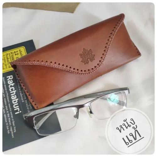 ซองแว่นตาหนังแท้สีน้ำตาล ทำจากหนังฟอกฝาดอิตาลี สามารถร้อยเข็มขัดได้ วางบนพื้นหลังสีขาว