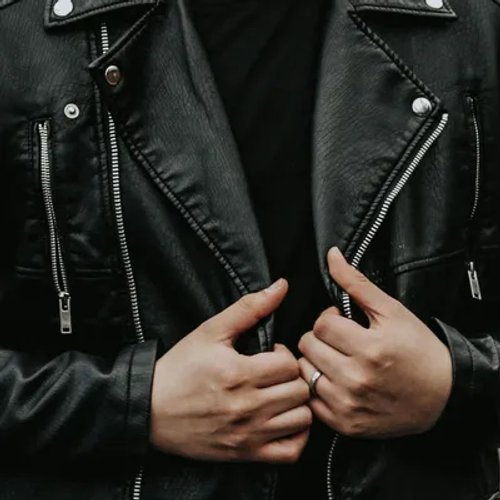 ชายสวมเสื้อแจ็คเก็ตหนังสีดำ กำลังจับปกเสื้อ สะท้อนรสนิยมส่วนตัว