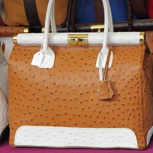 กระเป๋าหนังนกกระจอกเทศสีน้ำตาลขาว หูหิ้วและขอบด้านล่างสีขาว ตัวกระเป๋าสีน้ำตาล มีตัวล็อคทอง