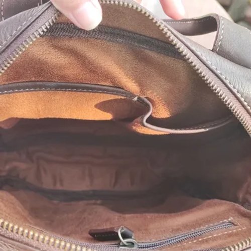 ภาพถ่ายภายในกระเป๋าหนัง PU สีน้ำตาล แสดงช่องหลัก ซิป และช่องเก็บของด้านใน