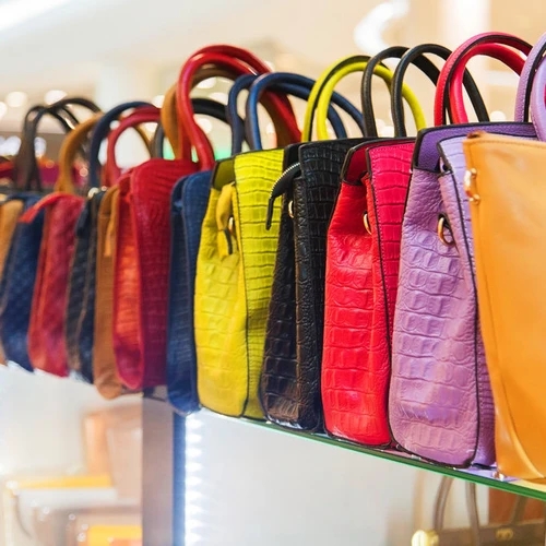 รวมสีกระเป๋ามาแรง 2569 ที่โดดเด่นและหลากหลายบนชั้นวางกระจกในร้านค้าแฟชั่น