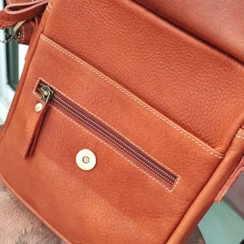 กระเป๋าหนังสีน้ำตาลที่ตัดเย็บอย่างประณีตพร้อมซิปและกระดุมแม่เหล็ก