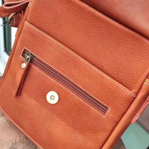 กระเป๋าหนังสีน้ำตาลที่ตัดเย็บอย่างประณีตพร้อมซิปและกระดุมแม่เหล็ก