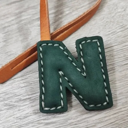 ที่ห้อยกระเป๋า N หนังแท้สีน้ำตาลเข้ม แขวนอยู่บนหูกระเป๋าถือของผู้หญิง - 05