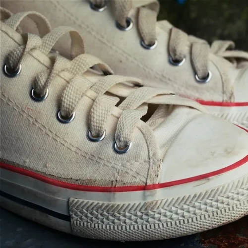 รองเท้าผ้าใบแคนวาสสีขาวที่เปื้อนคราบสกปรกหนัก รอการฟื้นฟูด้วยวิธีซักที่ถูกต้อง
