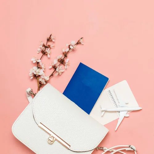 กระเป๋าหนังสีขาวกับการเดินทางพร้อมพาสปอร์ตและของตกแต่ง