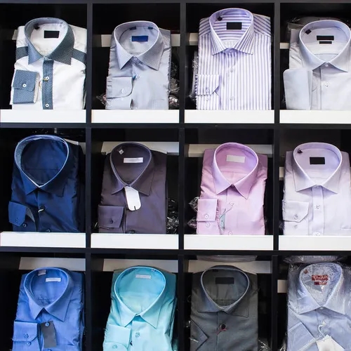 เสื้อเชิ้ตหลากสีสันและดีไซน์พับเรียงกันอย่างสวยงาม