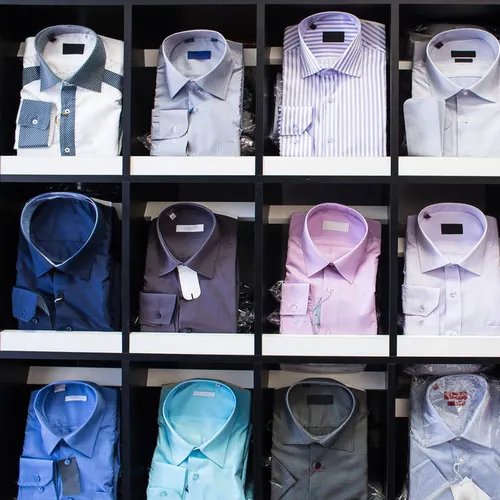 เสื้อเชิ้ตหลากสีสันและดีไซน์พับเรียงกันอย่างสวยงาม