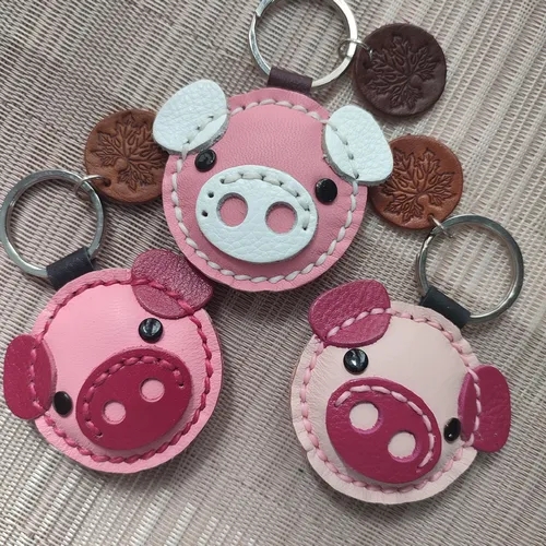 พวงกุญแจหนังรูปหน้าหมูแฮนด์เมดสีชมพูและขาว 3 สไตล์ พร้อมป้ายหนังสลักลายใบไม้