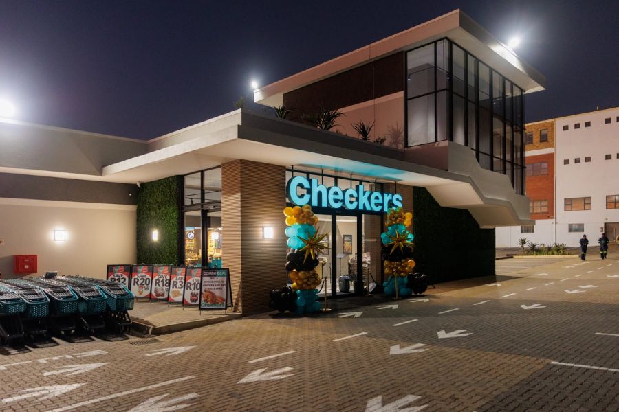 Checkers supermarket in Port Shepstone just before sunrise, with the storefront lit up against a soft dawn sky.