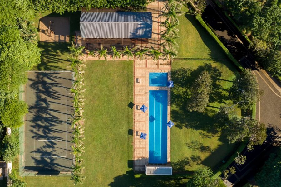 Aerial view of an estate’s lap pool, tennis court, lawns and palm-lined pavilion at Zinkwazi on the KZN North Coast
