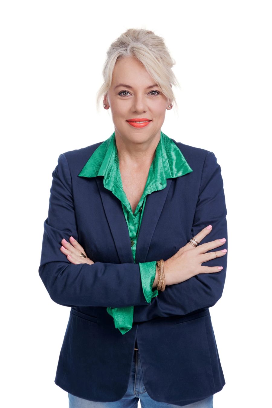 Corporate headshot of a woman with blonde hair in a navy blazer and green blouse, arms folded, against a white background, Studio 039, Sea Park.