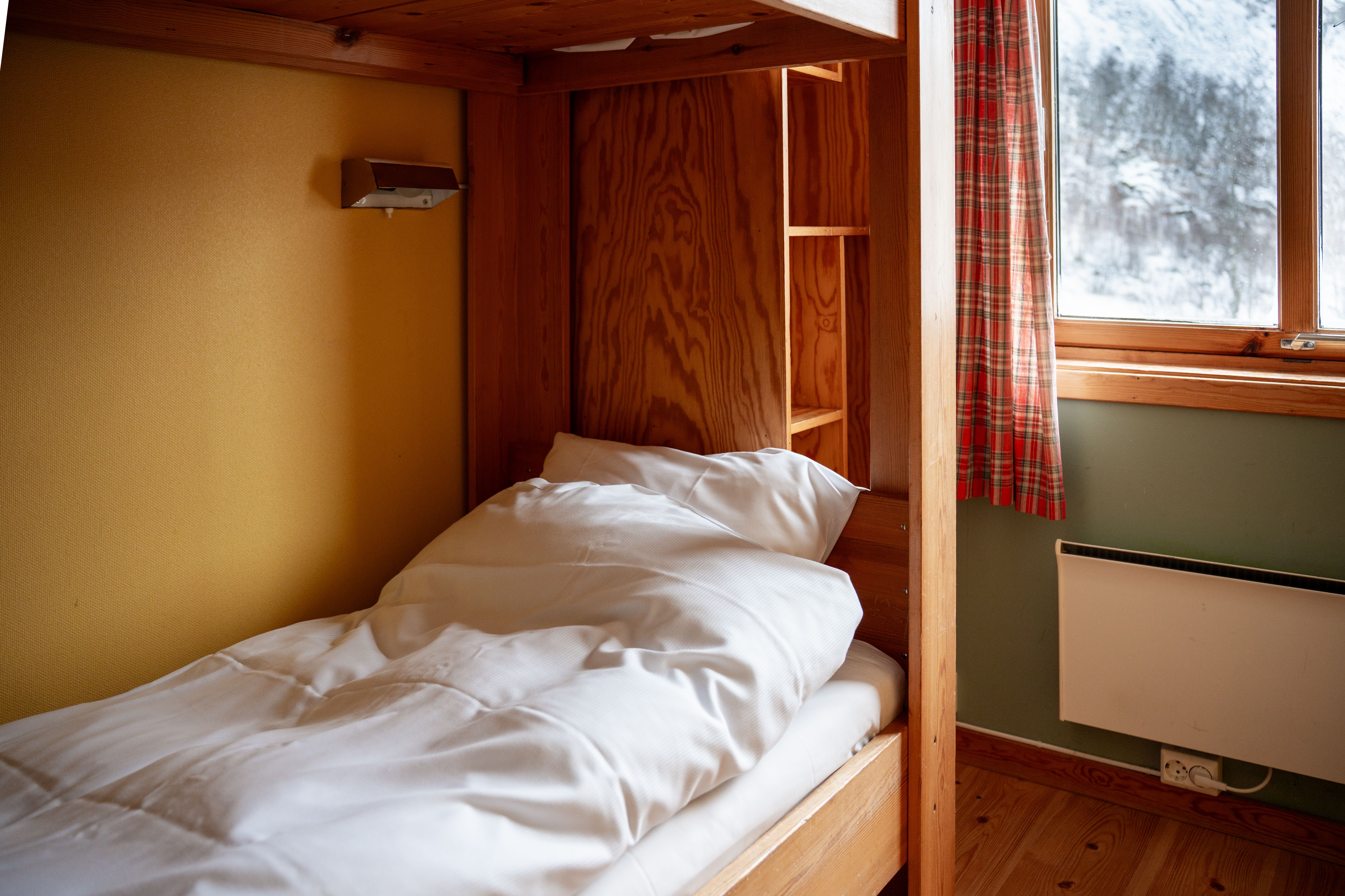 A warm private bunk room with exposed timber at Voss Mountain Lodge.
