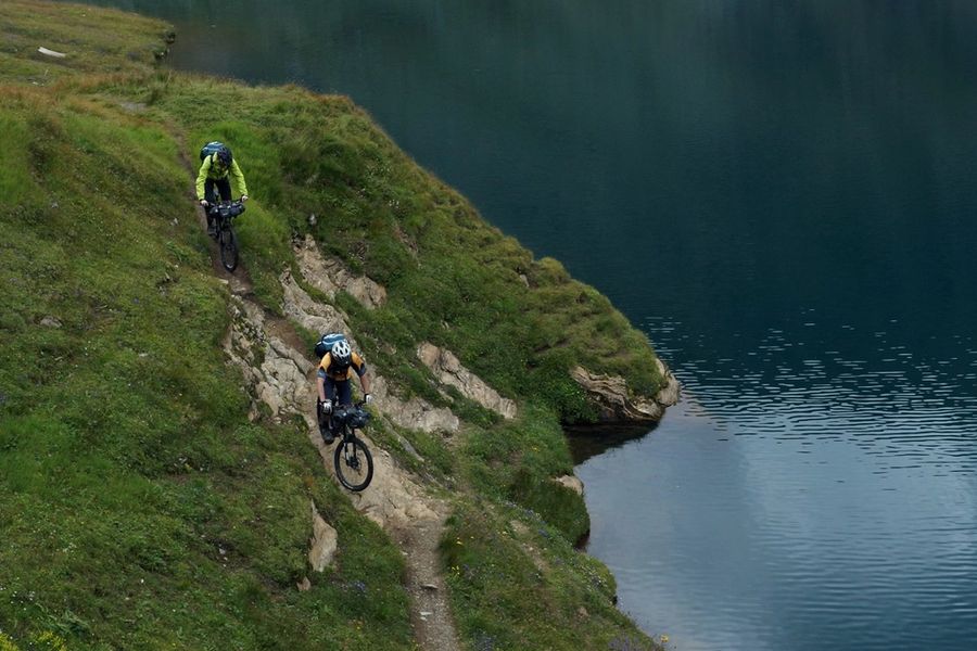 Mountain bikers riding along a lake in the summertime in Voss, Norway