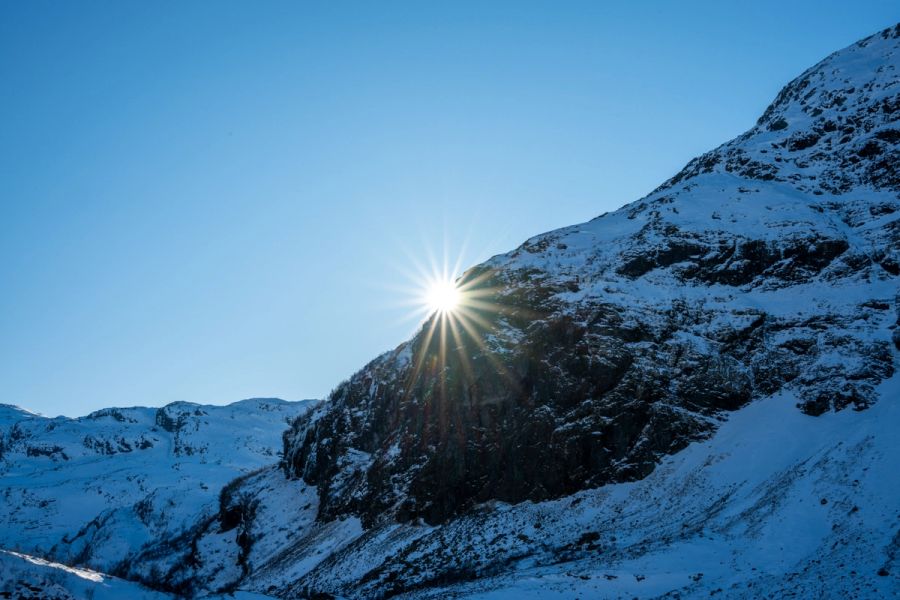 Bright sunburst over snow-covered mountains outside of Voss, Norway.