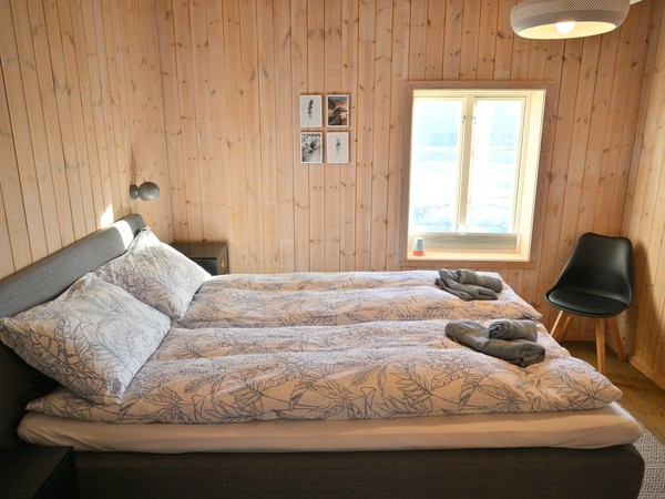 A cosy private bedroom with an all-wood interior at Lofoten Pier Lodge.